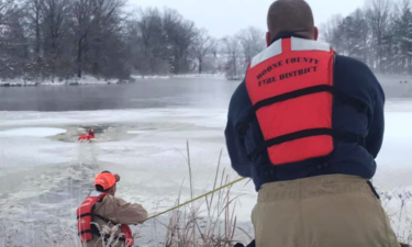 Firefighters work to pull a dog from a frozen pond off of Highway HH. Photo provided by the Boone County Fire Protection District