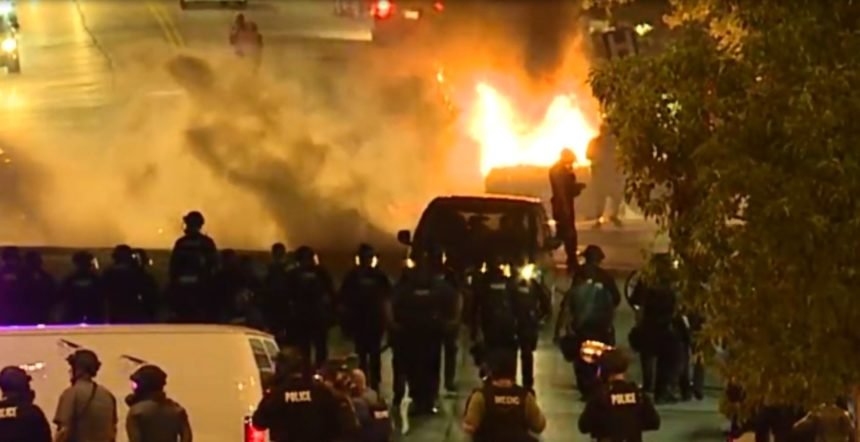 Protesters set fire to a police car in Kansas City.