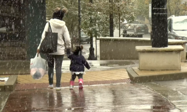 A mother and daughter walk through downtown Columbia while it snows.