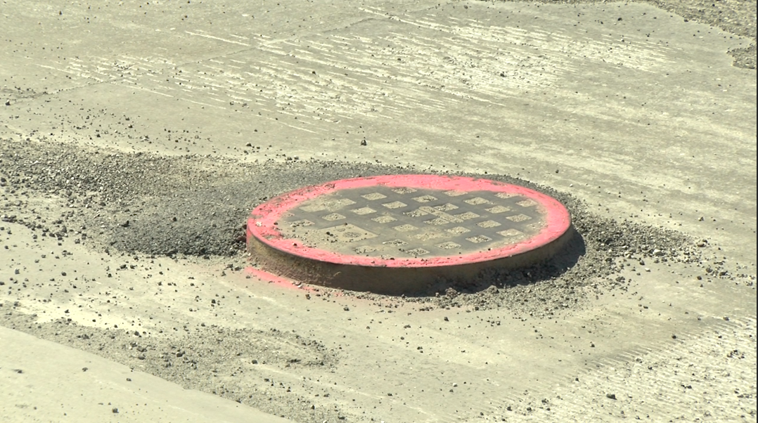 A manhole sticks up from the milled road surface on Stadium Boulevard on Friday, June 11, 2021.