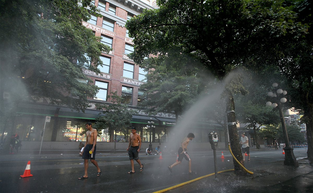 <i>Trevor Hagan/BloombergGetty Images</i><br/>A temporary misting station in Vancouver cools residents amid the extreme heat.