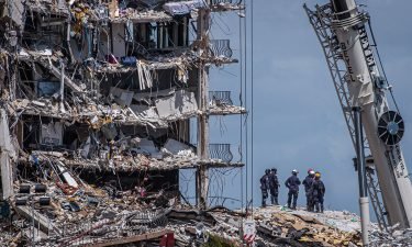 Members of the South Florida Urban Search and Rescue team look for possible survivors in the partially collapsed 12-story Champlain Towers South condo building.