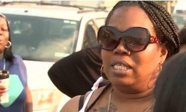 Wadyia Gregory (sunglasses) speaks at a vigil for her 16-year-old son