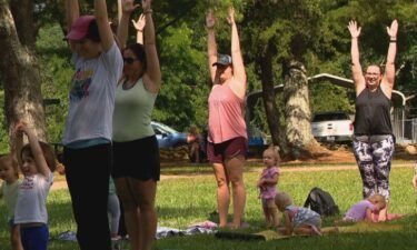 Moms and children participate in an outdoor yoga class designed to help little people focus on their minds and bodies.