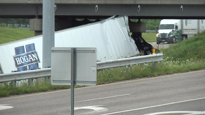 Crews work to remove a semi truck from under a bridge at the connector