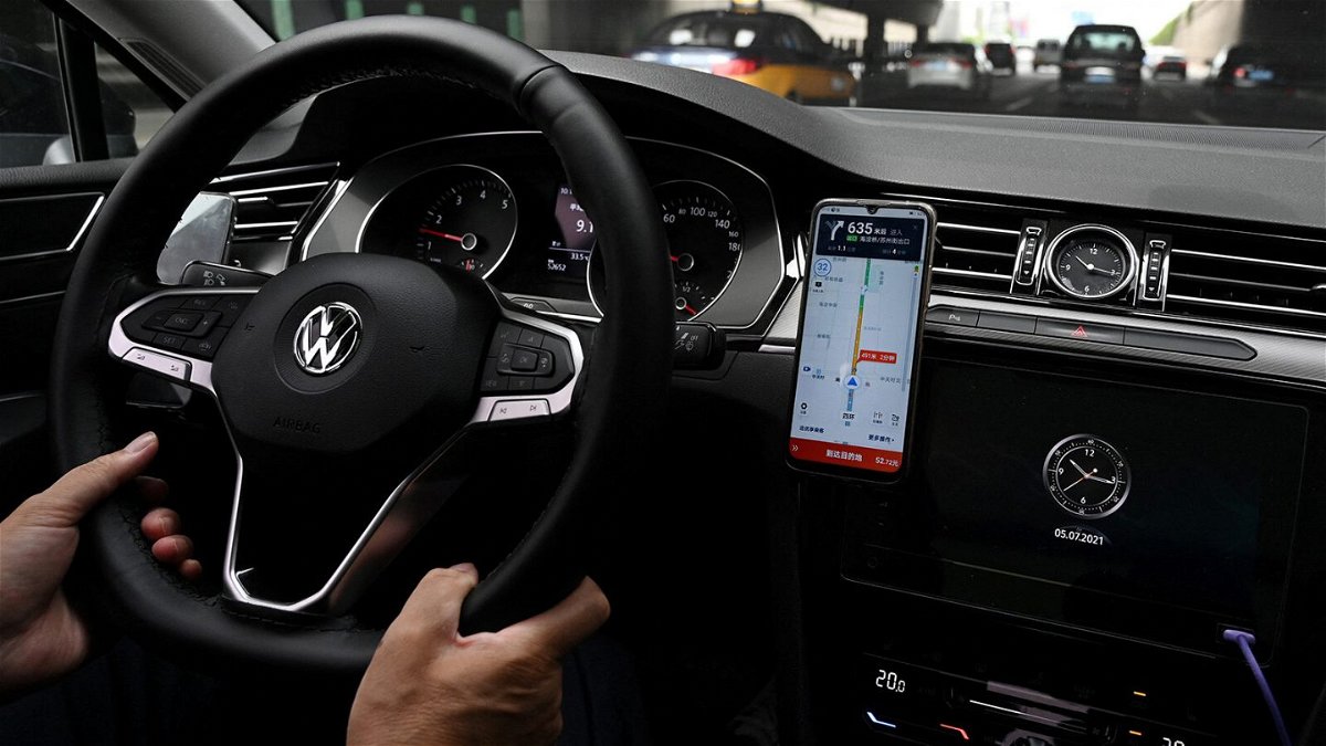 <i>Greg Baker/AFP/Getty Images</i><br/>A driver uses the map on the Didi Chuxing ride-hailing app on his smartphone while driving on a street in Beijing on July 5. Shares in Didi crashed 20% after Chinese authorities opened an investigation into the ride-hailing giant that raised $4.4 billion last week in a massive IPO in New York.