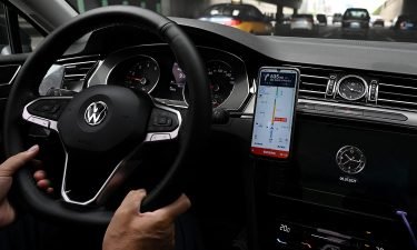 A driver uses the map on the Didi Chuxing ride-hailing app on his smartphone while driving on a street in Beijing on July 5. Shares in Didi crashed 20% after Chinese authorities opened an investigation into the ride-hailing giant that raised $4.4 billion last week in a massive IPO in New York.