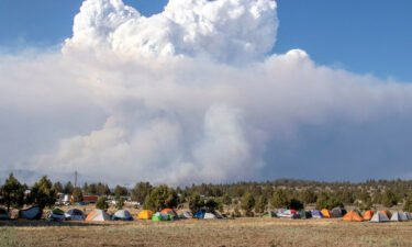 A pyrocumulus cloud caused by the Bootleg Fire drifts north of a firefighter operating base in Bly
