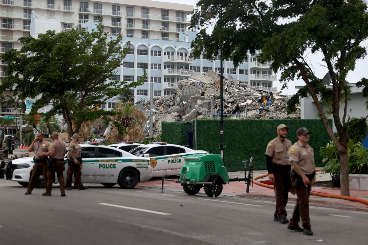 <i>Joe Raedle/Getty Images</i><br/>Miami-Dade police officers helping with the search and rescue stand near the completely collapsed 12-story Champlain Towers South on July 6