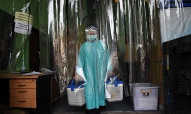 A health worker delivers containers of Sinovac vaccines from a cold room in Bandung
