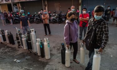 Residents queue up to get oxygen tanks refilled at a refilling station in Surabaya on July 15.