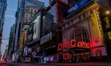 Signage is displayed outside an AMC movie theater at night in the Times Square neighborhood of New York on Oct. 15