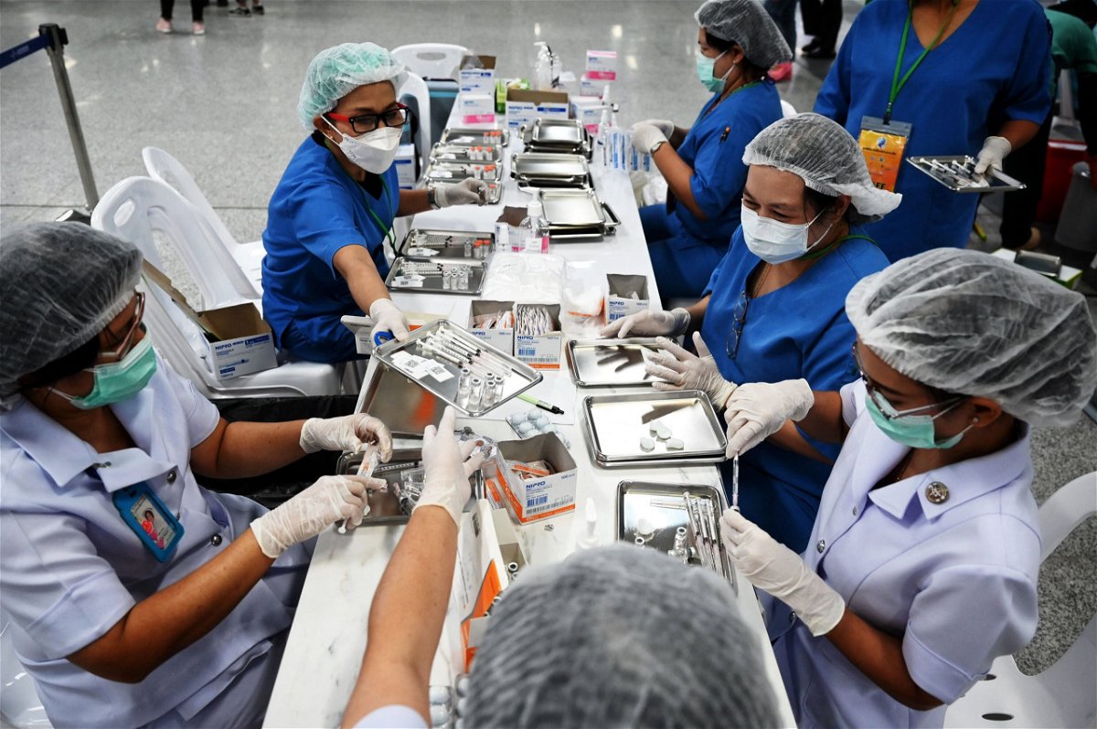 <i>Lillian Suwanrumpha/AFP/Getty Images</i><br/>Health workers prepare doses of the CoronaVac vaccine in Bangkok on June 22.