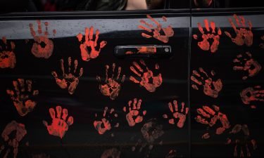 Handprints on the side of a truck riding in a convoy of vehicles in support of the Tk'emlups te Secwepemc people