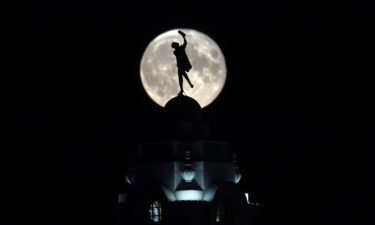 The full buck moon rises over a dancing lady on the Spanish City building in Whitley Bay