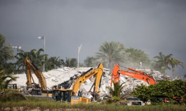 Rescue workers use excavators to dig through the rubble of the collapsed 12-story Champlain Towers South condo building on July 9 in Surfside