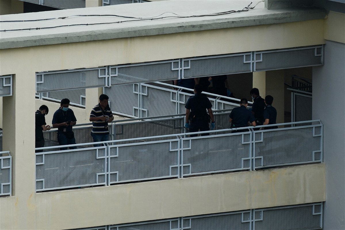 <i>Roslan Rahman/AFP/Getty Images</i><br/>Police officers are seen along a corridor at River Valley High School in Singapore on July 19. A 16-year-old boy was due to be charged with murder by Singapore police after a 13-year-old boy was found dead with multiple wounds in a school bathroom along with an ax.