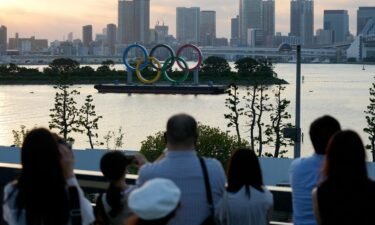 Visitors look at the Olympic rings floating in the water at Odaiba Marine Park