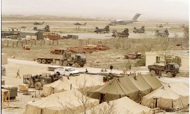 US military aircraft populate the runways of Bagram air base while tents are set up in the foreground on April 4