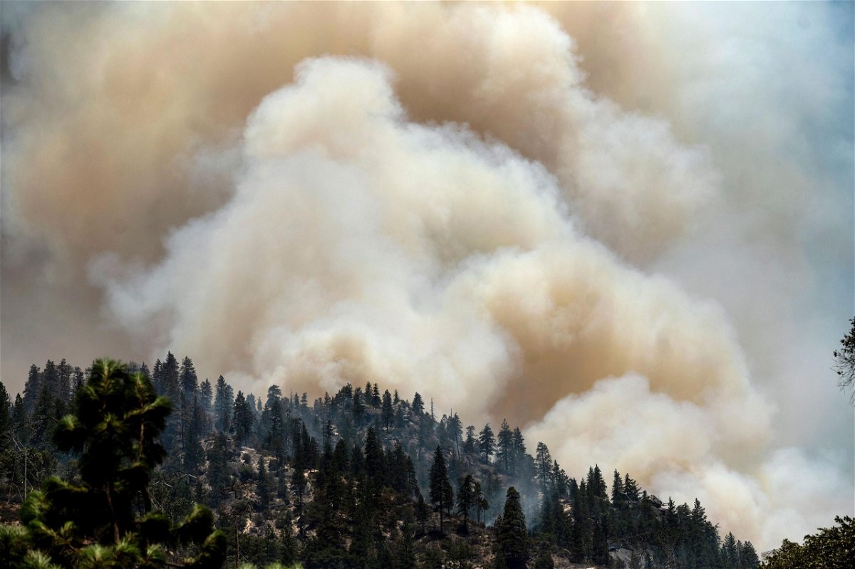 <i>Noah Berger/AP</i><br/>Smoke rises from the Dixie Fire burning along Highway 70 in Plumas National Forest on July 16. PG&E announced July 21 that it will bury 10
