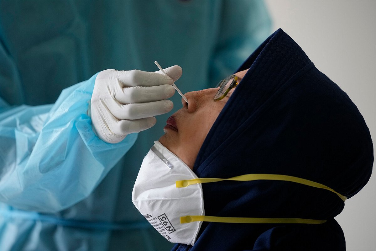 <i>Dita Alangkara/AP</i><br/>A woman has her nasal swab samples collected during mass testing for Covid-19 in Bekasi on the outskirts of Jakarta