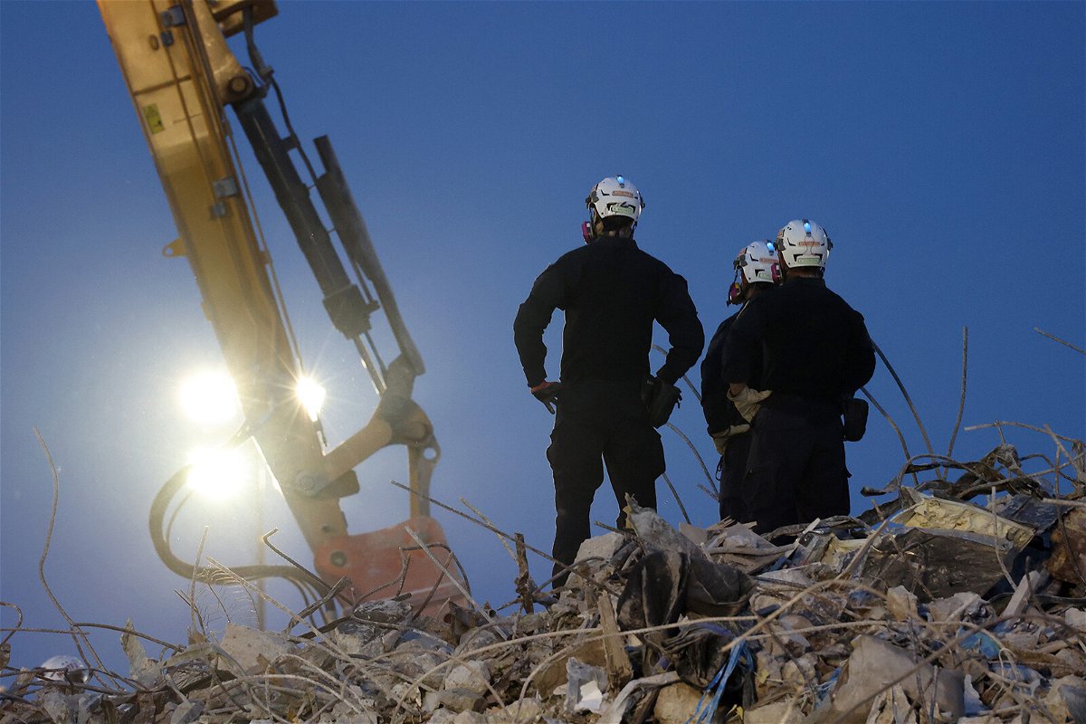 <i>Anna Moneymaker/Getty Images</i><br/>Search and rescue workers oversee an excavator dig through the rubble of the collapsed Champlain Towers South condo building.