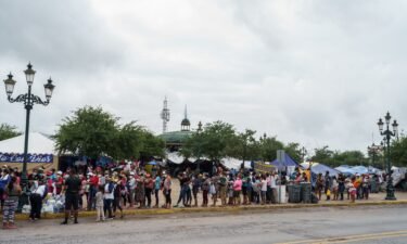 Migrants who were sent back to Mexico under Title 42 wait in line for food and supplies in a camp across the US-Mexico border earlier this month.