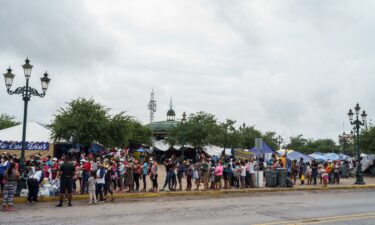 Migrants who were sent back to Mexico under Title 42 wait in line for food and supplies in a camp across the US-Mexico border in Reynosa