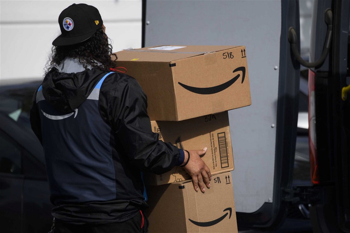 <i>PATRICK T. FALLON/AFP/Getty Images</i><br/>An Amazon.com Inc. delivery driver carries boxes into a van outside of a distribution facility on February 2 in Hawthorne