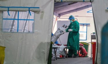 A medical personnel changes out an oxygen tank in a tent set up at a public hospital to handle the overflow of Covid-19 patients on June 24 in Jakarta