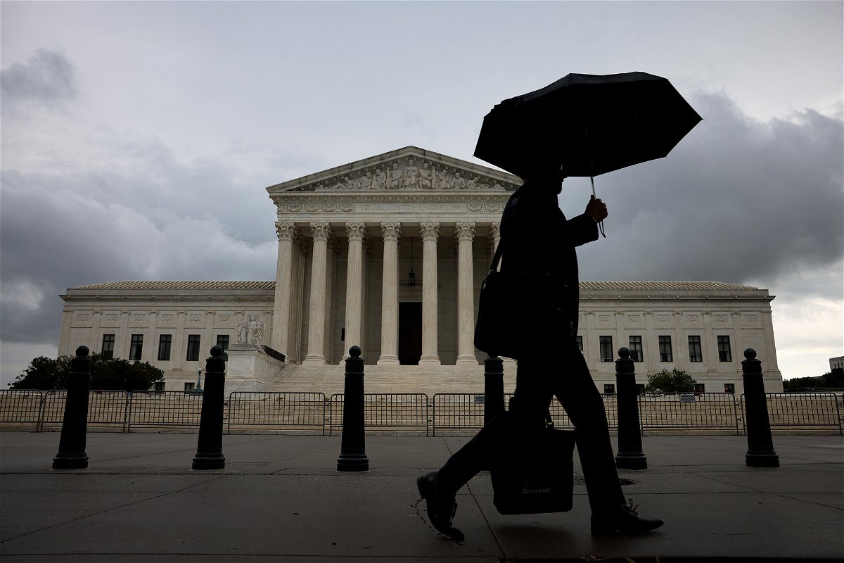 <i>Anna Moneymaker/Getty Images</i><br/>A morning commuter walks passed the U.S. Supreme Court on June 22 in Washington