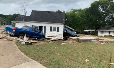 Vehicles are shown crashing through a house after flooding damage in Tennessee on August 21.