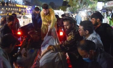 Volunteers and medical staff unload bodies from a pickup truck outside a hospital after two powerful explosions outside the airport in Kabul on August 26.