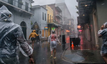 A group of people walk through the French District during Hurricane Ida on August 29