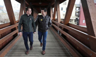 Pete Buttigieg (R) walks with his husband