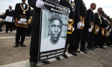 A marcher holds a poster of Jimmie Lee Jackson