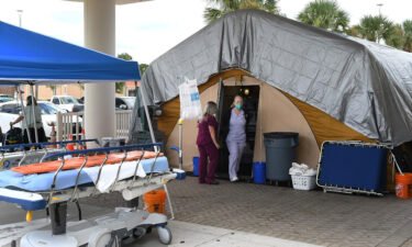 Nurses work at a treatment tent outside the emergency department at Holmes Regional Medical Center in Melbourne