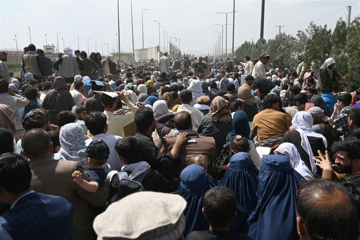 <i>Wakil Kohsar/AFP/Getty Images</i><br/>Afghans gather on a roadside near the military part of the airport in Kabul on August 20