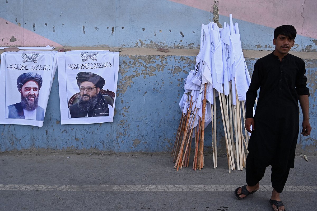 <i>Aamir Qureshi/AFP/Getty Images</i><br/>A vendor selling Taliban flags stands next to the posters of Taliban leaders Mullah Abdul Ghani Baradar and Amir Khan Muttaqi