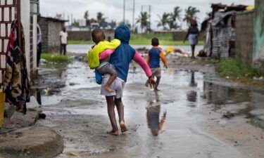 A child walks near rising waters in the Praia Nova neighborhood in Beira