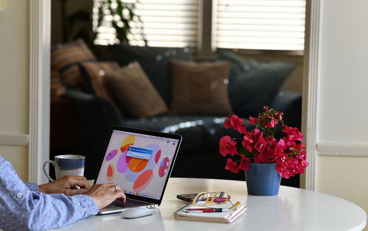 <i>Chris Delmas/AFP/Getty Images</i><br/>Synchrony CEO: We'll never go back to the old way of working. This illustration photo shows a person working on their laptop from a home office in Los Angeles on August 14.