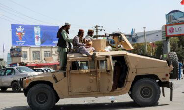 Taliban fighters drive an American Humvee in Kabul on Monday