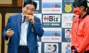 Nagoya Mayor Takashi Kawamura bites the Olympic gold medal of Miu Goto.