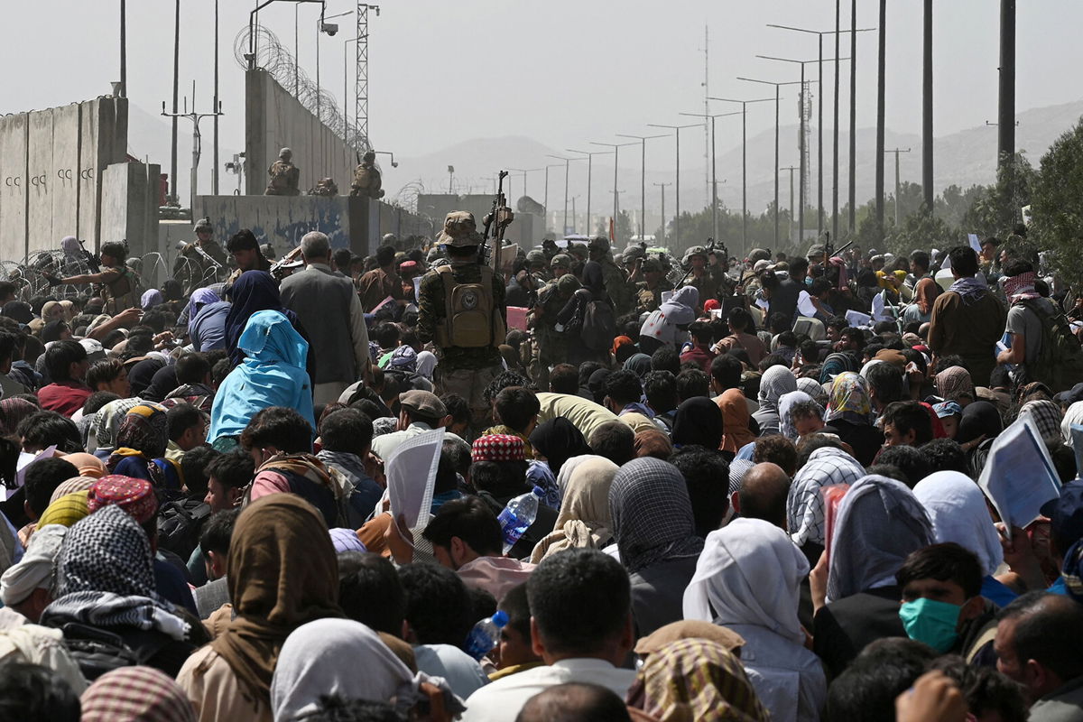 <i>Wakil Kohsar/AFP/Getty Images</i><br/>Afghans gather on a roadside near the military part of the airport in Kabul on August 20