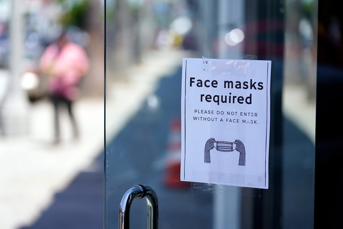 <i>Marcio Jose Sanchez/AP</i><br/>A sign advises shoppers to wear masks outside of a store on July 19 in the Fairfax district of Los Angeles.