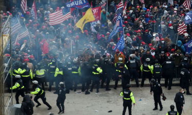 Police hold back supporters of former President Donald Trump as they gather outside the US Capitol's Rotunda on January 6