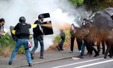 Members of the far-right group Proud Boys and counterprotesters spray mace at each other during clashes on Sunday in northeast Portland.