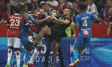 Dimitri Payet (second left) reacts as players from Nice and Marseille stop a fan invading the pitch.
