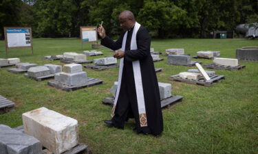 Rev. Lee Gandiya of St. Paul's Episcopal Church blesses gravestones during a ceremonial transfer.