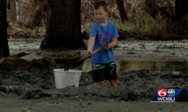 A boy shovels the mud to get to his home in lower Lafitte.